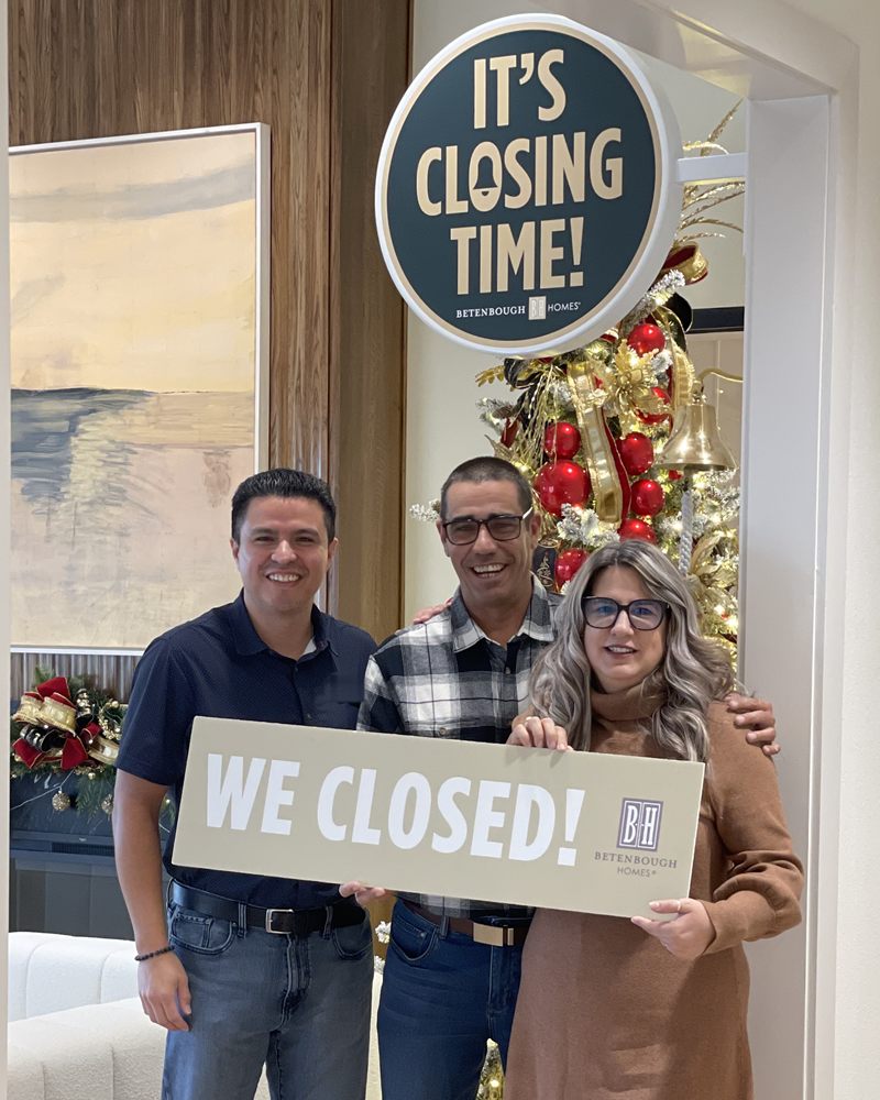 Perea Mortgage clients celebrating their home closing with a We Closed sign