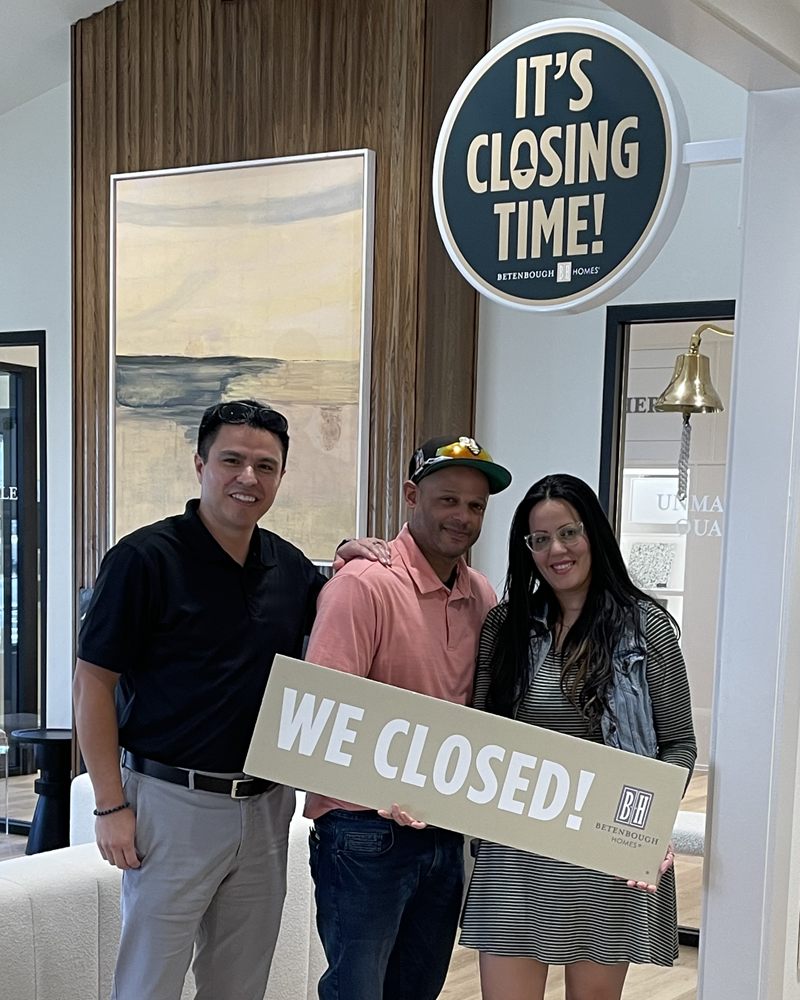 Perea Mortgage clients celebrating their home closing with a We Closed sign